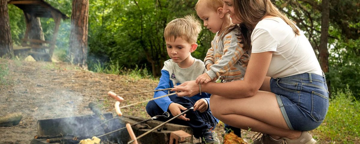 Family enjoying campfire s’mores at Jellystone Park™ Cherokee before the school year begins.