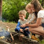 Family enjoying campfire s’mores at Jellystone Park™ Cherokee before the school year begins.