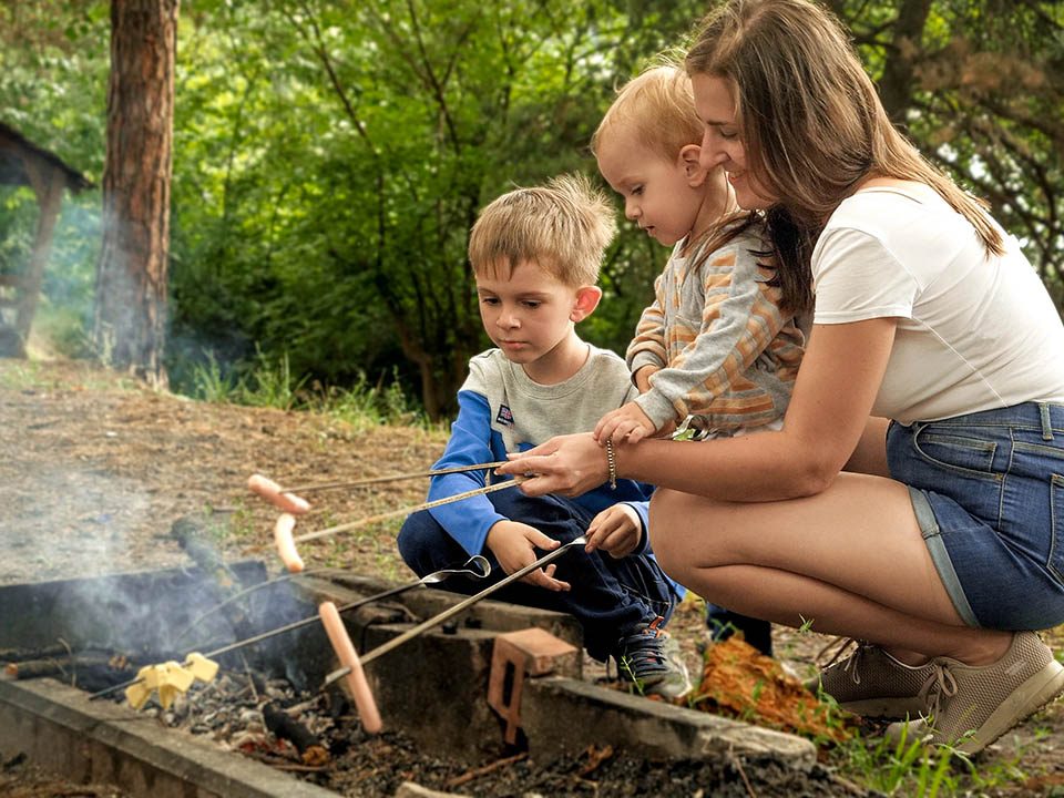 Family enjoying campfire s’mores at Jellystone Park™ Cherokee before the school year begins.